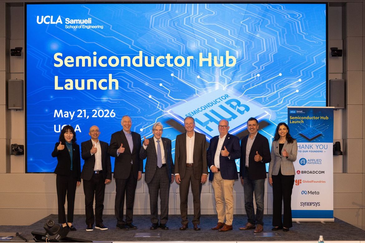Eight dignitaries stand with thumbs up in front of a big blue screen showing the words 'Semiconductor Hub Launch,' May 21, 2026